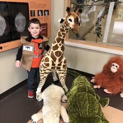 Preschool Pride kid wearing kid-crafted keeper vest with large stuffed animals